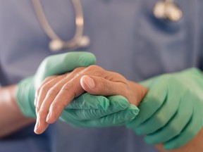 The health care worker holds the patient's hands.